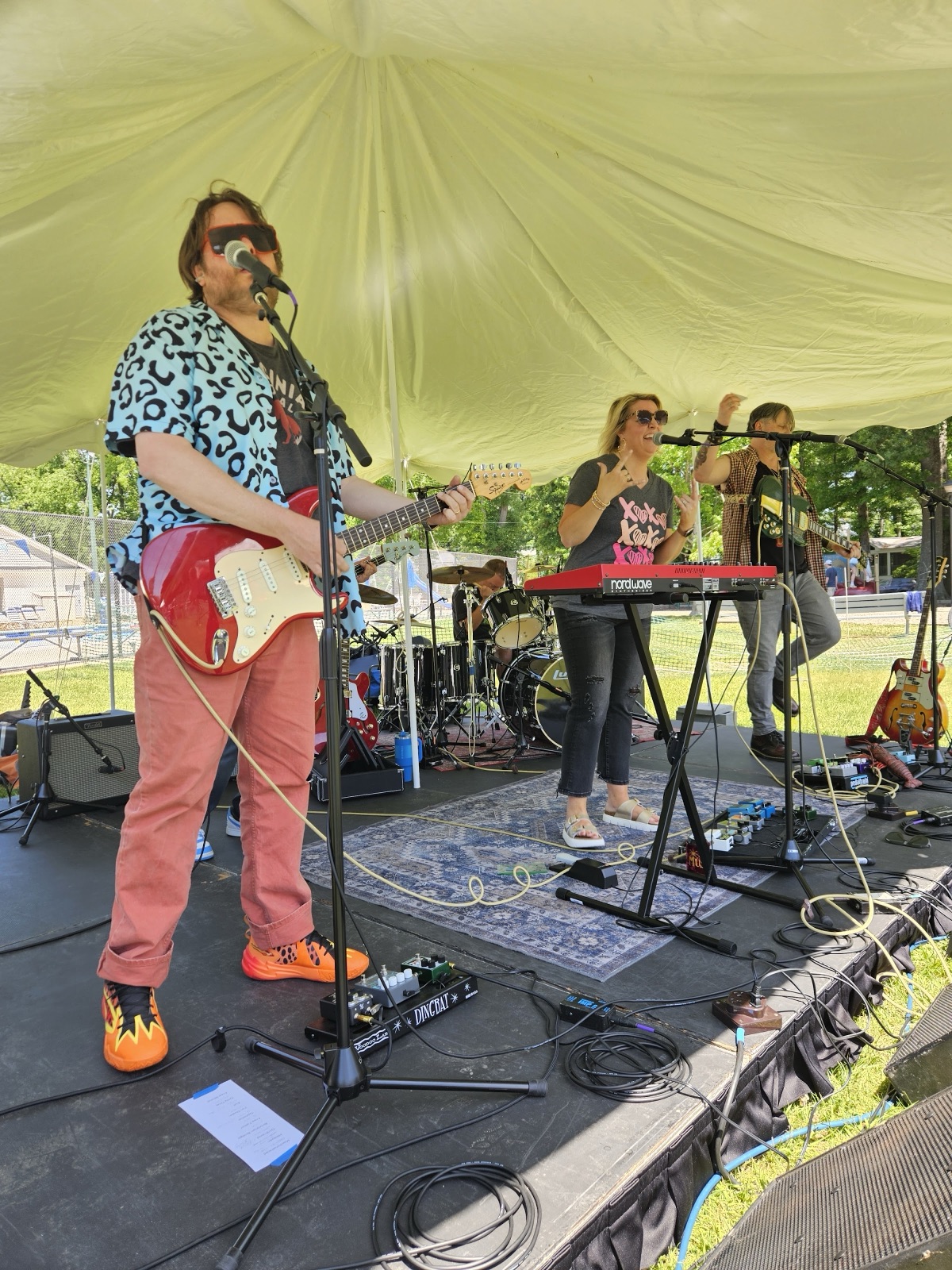 Lead singer in a leopard-print shirt jamming with the full band on the Waynewoodstock 2026 main stage